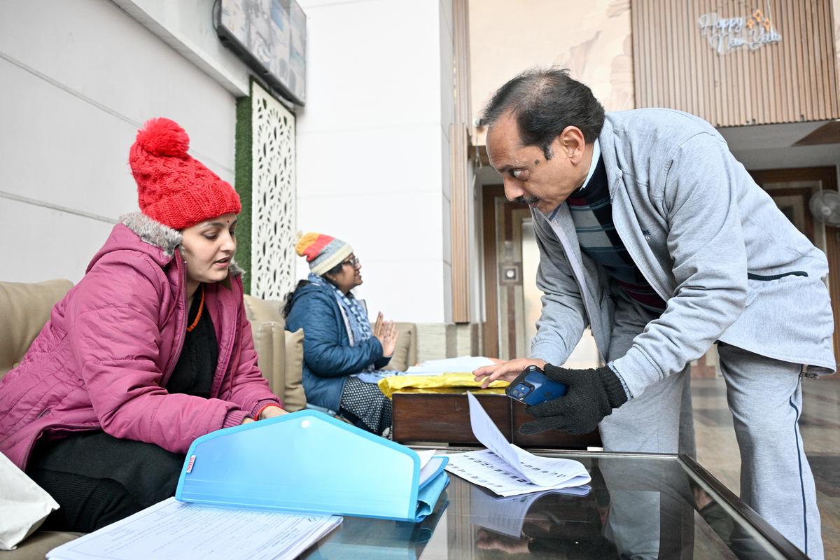 11 जनवरी, 2026 को उत्तर प्रदेश के गाजियाबाद की एक आवासीय सोसायटी में एक व्यक्ति मतदाता सूची के विशेष गहन पुनरीक्षण (एसआईआर) के बाद मसौदा मतदाता सूची में नाम ढूंढ रहा है। 